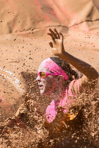 Vrouw spatten modderig Water op vuile meisje Mud Run evenement — Stockfoto