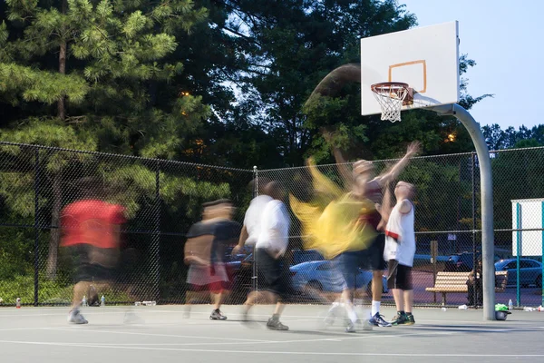 Молодые люди движения размытие играя на открытом воздухе пикап баскетбольная игра — стоковое фото