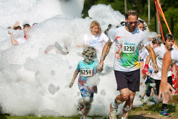 Father And Son Run Through Foamy Bubbles At Bubble Palooza