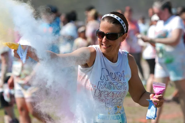 Mujer lanza almidón de maíz coloreado en evento de palooza de burbuja — Foto de Stock