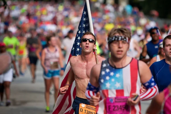 Jonge man draagt grote Amerikaanse vlag in atlanta 10k race — Stockfoto