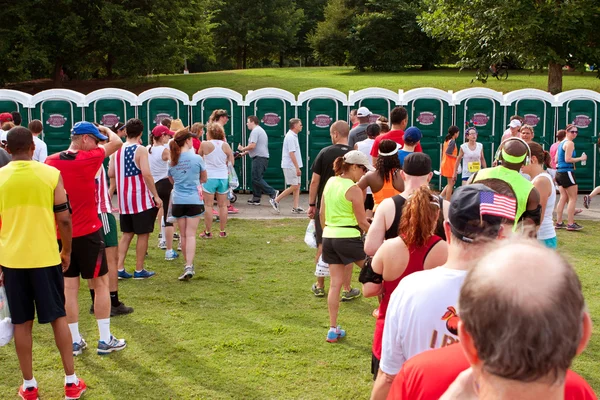 10 k lopers wachten in de rij te gebruiken draagbare toiletten — Stockfoto