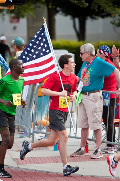 Runner porta bandiera americana nel luglio 4 Atlanta Road Race — Foto Stock