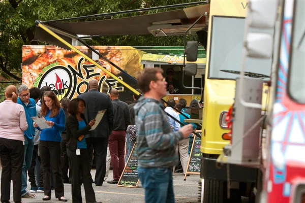 La gente espera en la cola para comprar comidas en camiones de comida — Foto de Stock