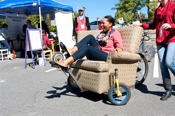 Woman Steers Oddball Furniture Piece On Wheels At Unique Fair — Stock Photo, Image