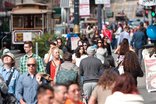 Crowd Of People Walk Among Trolley Cars in San Francisco
