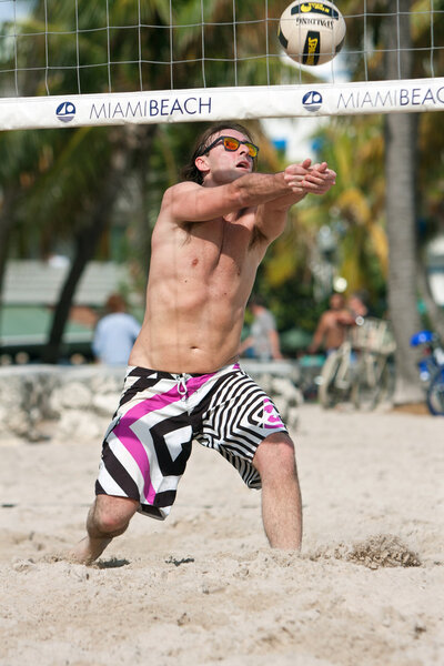 Man Uses Arms To Pass Ball In Beach Volleyball Game