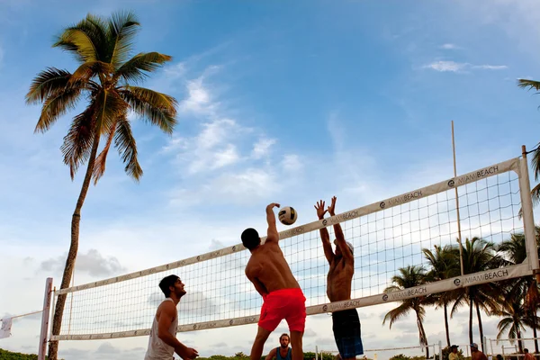 Hombre Spikes Ball Bloqueador pasado en Miami Beach Voleibol Juego Fotos de stock libres de derechos