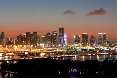Pembe günbatımı karşı alacakaranlıkta Miami manzarası yanar