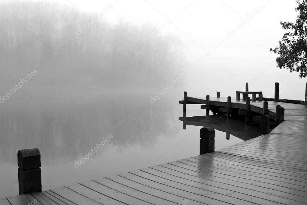 Thick Fog Covers Wooden Dock And Lake On Winter Day