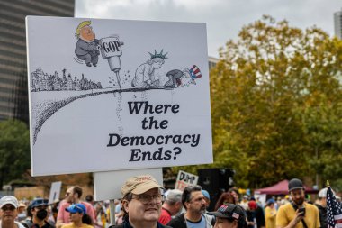 Atlanta, GA / ABD - 18 Ekim 2025: Bir adam 18 Ekim 2025 'te Atlanta, GA' da düzenlenen No Kings 2 mitinginde büyük bir demokrasi yanlısı tabela sergiliyor..