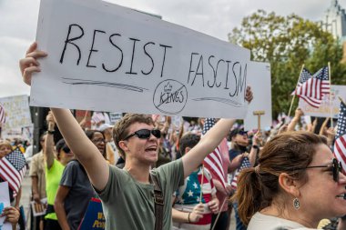 Atlanta, GA / ABD - 18 Ekim 2025: 18 Ekim 2025 'te Atlanta, GA' da düzenlenen No Kings 2 mitingine katılan genç bir erkek anti-faşizm işareti taşıyor..