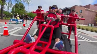 Lawrenceville, GA / USA - 26 Nisan 2025: POV izleme ekibi, 26 Nisan 2025 'te GA' nın Lawrenceville kentinde evsizler için yerel bir bağış toplama etkinliğinde ev yapımı yatağı itiyor..