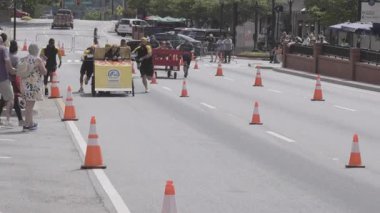 Lawrenceville, GA / USA - 20 Nisan 2024: İki takım, 20 Nisan 2024 'te Lawrenceville, GA' da evsizler için yerel bir bağış toplama etkinliğinde, tekerlek üzerinde ev yapımı yatakları itmeye çalıştı..