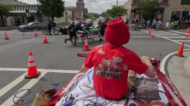 Lawrenceville, GA / USA - 20 Nisan 2024: POV izleme çekimi, ekiplerin 20 Nisan 2024 'te Lawrenceville, GA' da evsizler için yerel bir bağış toplama etkinliğinde ev yapımı yatakları ittiğini gösteriyor..