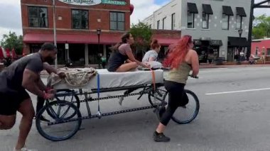 Lawrenceville, GA / USA - 26 Nisan 2025: İzleme çekimleri, 26 Nisan 2025 'te Lawrenceville, GA' da evsizler için yerel bir bağış toplantısında iki takımın ev yapımı yatakları ittiğini gösteriyor..