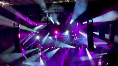 Mor ve beyaz ışıklı ışıklar dumanı kesiyor ve bir konserde çılgınca hareket ediyor, canlı, hareketli ışıklardan oluşan bir arka plan tabakası oluşturuyor..