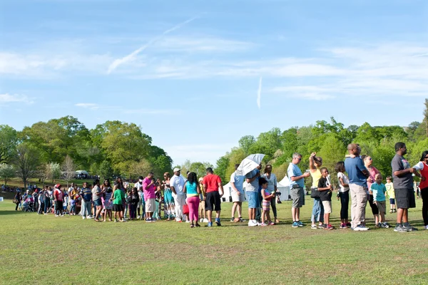 Padres e hijos esperan en larga cola para el paseo del festival —  Fotos de Stock
