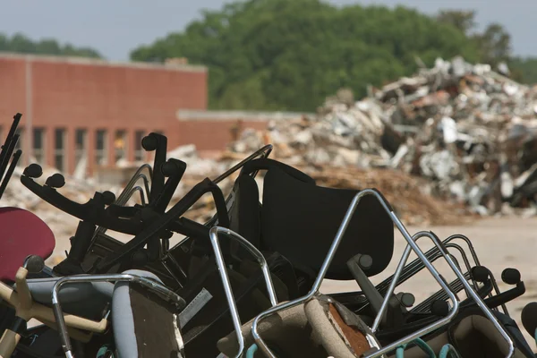 Pieux de chaises de bureau et de débris jetés sur le site de démolition — Photo