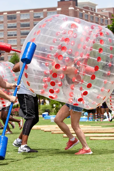 女性は、プラスチック製のボールを身に着けているアトランタのイベントでバブルのガントレットを実行します。 — ストック写真