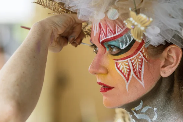 Künstlerin trägt Körperfarbe auf Gesicht weiblicher Models auf — Stockfoto