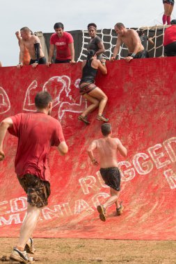 Competitors Attempt To Climb Wall In Extreme Obstacle Course Race clipart
