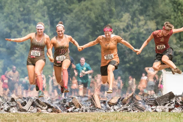Mujer Hurdle Burning Logs Together In Extreme Obstacle Course Race — Foto de Stock