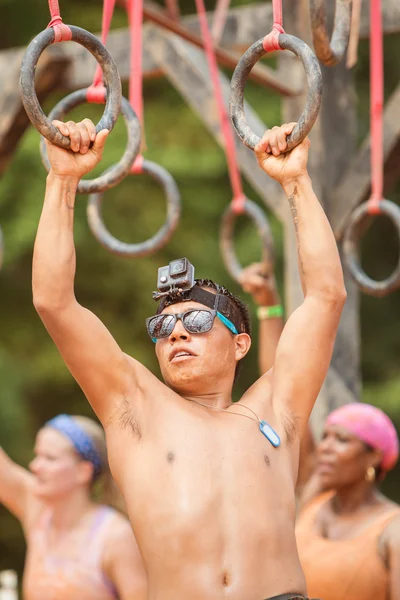 El hombre se aferra a los anillos suspendidos en carrera de obstáculos extremos — Foto de Stock