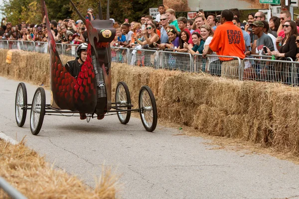 Man stuurt Dragon voertuig Down Street In Soap Box Derby — Stockfoto