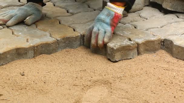 Worker installing old cobblestone block for build floor ground — Stock Video