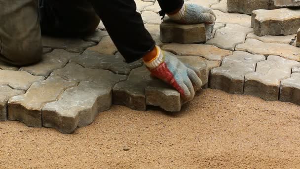 Worker installing old cobblestone block for build floor ground — Stock Video