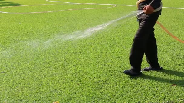 在美丽的绿草坪上浇水的人 — 图库视频影像