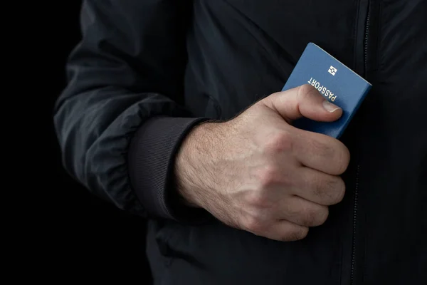 Siyah arka planda erkek pasaportu. Yasadışı göç kavramı.