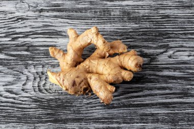 Siyah ahşap zemin üzerinde zencefil kökü.