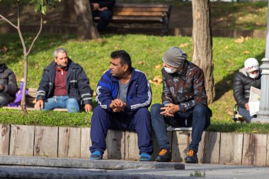 İSTANBUL, Turkey - 6 Ocak 2021. Parktaki banklarda oturan adamlar.