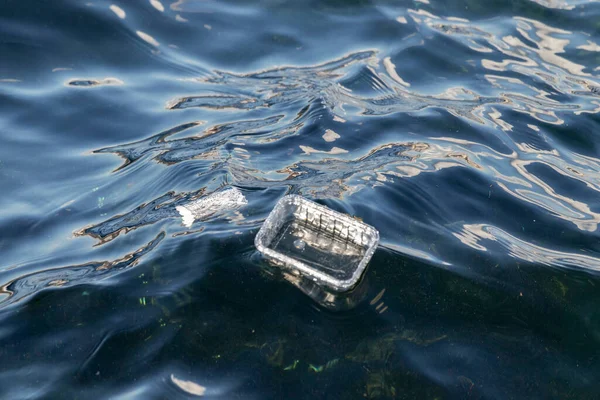 Plastik atıklar deniz dalgalarında yüzer. Su yüzeyindeki plastik çöpler..
