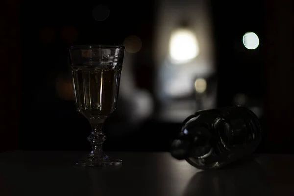 Una Copa Vino Una Botella Vacía Sobre Mesa Cuarto Oscuro — Foto de Stock