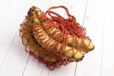 Muzlu kırmızı ipli alışveriş torbası. Beyaz ahşap bir masada.