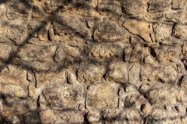 Ağaç gölgeli eski taş duvarın tam kare fotoğrafı. Antika taş duvar arkaplanı.