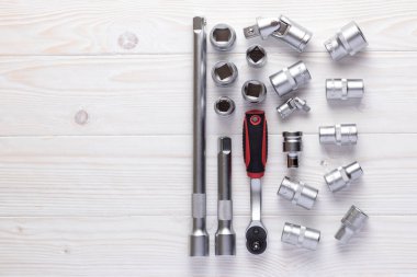 Beyaz ahşap bir masa üzerinde değiştirilebilir nozülleri ile Ratchet anahtarı.