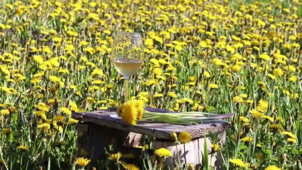 Copo Vinho Com Vinho Amarelo Dente Leão Uma Cadeira Madeira — Vídeo de Stock