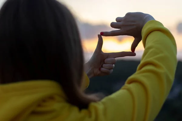 Woman Yellow Hoodie Looks Sunset Finger Frames — Stock Photo, Image