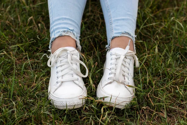 Patas Femeninas Jeans Azules Zapatillas Blancas Sobre Hierba Verde — Foto de Stock