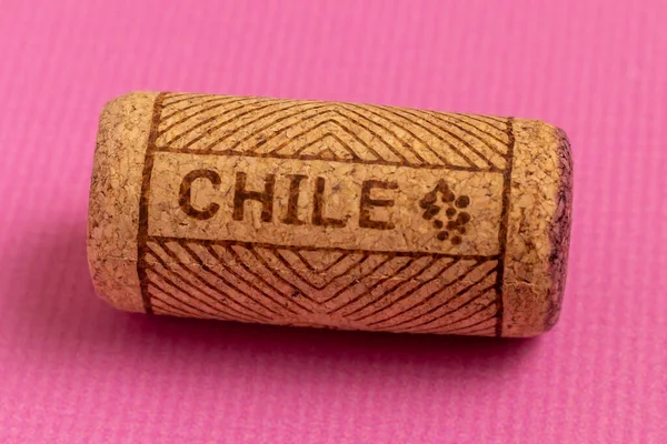 ワインコルクのクローズアップ ピンクの背景で ワインカントリーの名前チリはコルクに書かれています — ストック写真