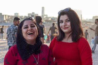 10 Eylül 2021 - Erbil, Irak. Kırmızı elbiseli genç Kürt kadınlar.