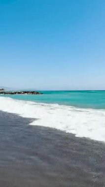 ALMUNECAR, SPAIN - 28 AĞUSTOS 2025: İspanya 'nın Almunecar kentindeki fırtınalı turkuaz dalgalar altında dramatik gökyüzü ve güçlü sörfler altında dinlenmek.