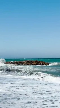 İspanya, Almunecar 'da fırtınalı turkuaz dalgalar altında, dramatik gökyüzü ve güçlü sörfler altında dinleniyor..