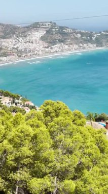 İspanya 'nın Herradura yakınlarındaki denizin turkuaz dalgaları, parlak güneş ışığı altında yavaşça kıyıya doğru yuvarlanıyor..