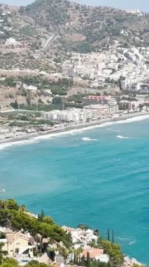 İspanya 'nın Herradura yakınlarındaki denizin turkuaz dalgaları, parlak güneş ışığı altında yavaşça kıyıya doğru yuvarlanıyor..