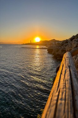Sunset over the sea in Rincn de la Victoria, Malaga, Spain, with golden light reflecting on calm waves along the coast.
